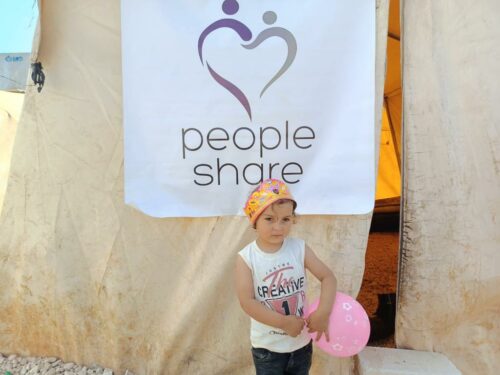 Kind steht vor der Zelt mit PeopleShare Logo